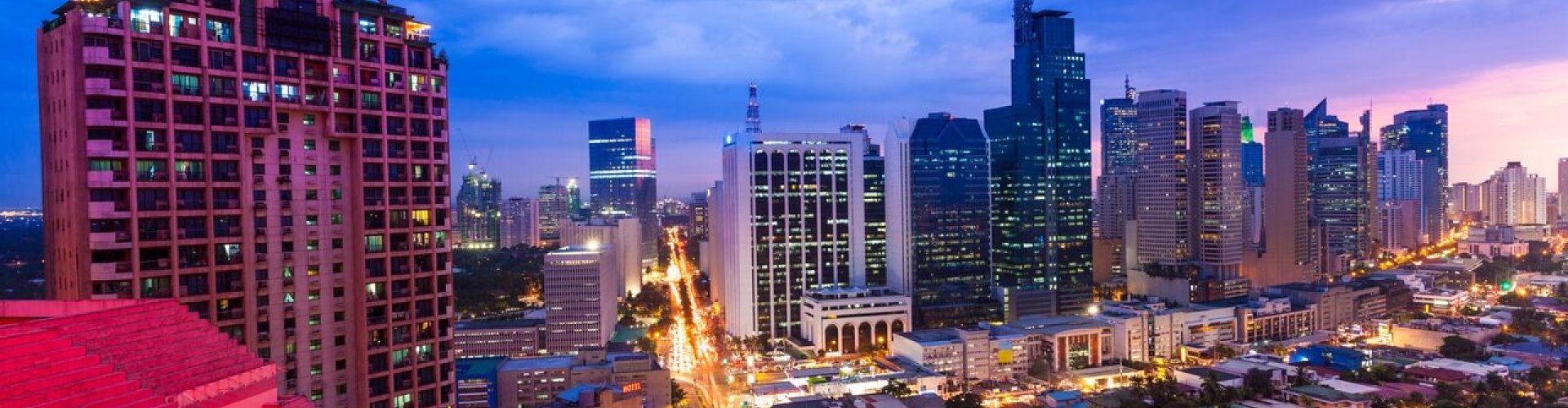 Manila night skyline with parked cars