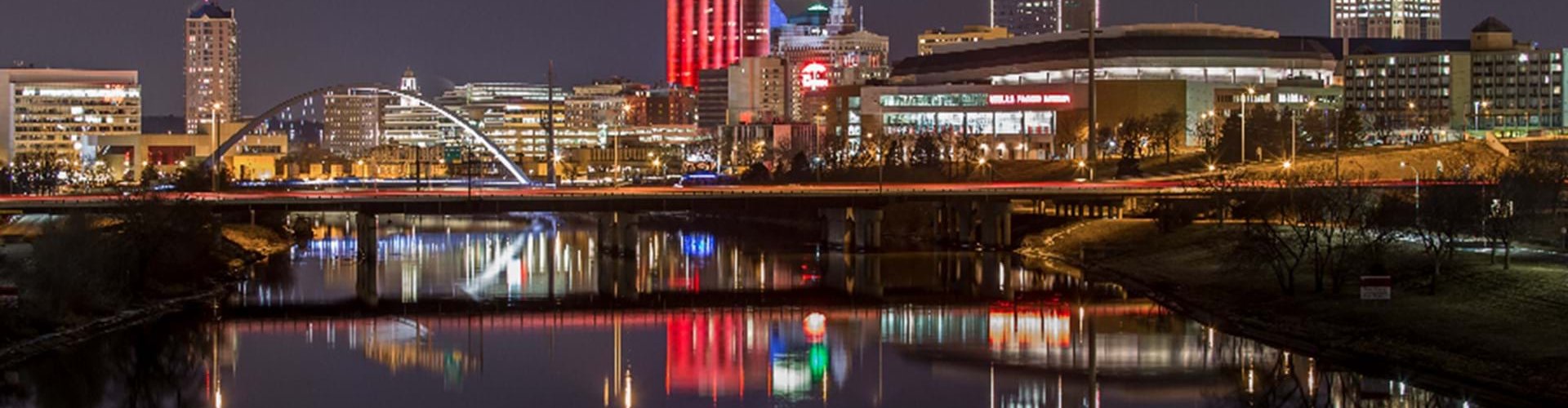 Des Moines night skyline with parked cars