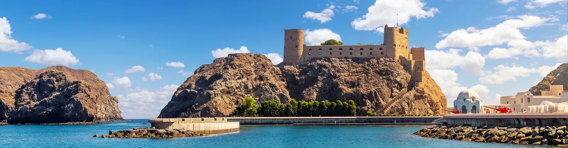 Muscat night skyline with parked cars